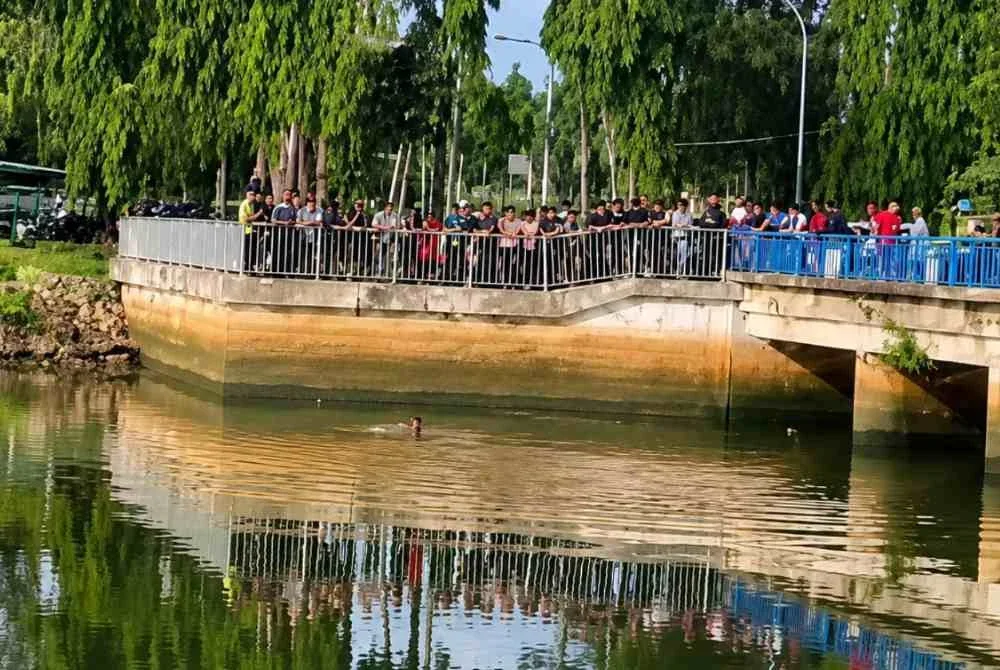 Polis mengambil masa selama 30 minit memujuk seorang lelaki terapung di dalam sungai dalam keadaan berbogel di Gate Air Pengkalan Petah, Tawang, Bachok pada Selasa. Foto tular. 
