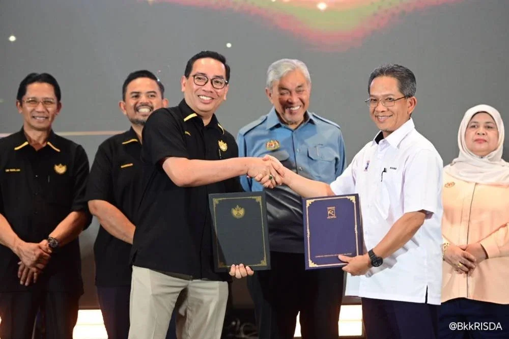 Ahmad Zahid menyaksikan pertukaran dokumen MoU antara Zainal Azni (hadapan, kiri) dan Pengurus Besar KESEDAR, W Muhd Rahimi Wan Salleh (kanan).