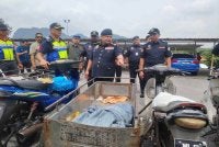Ahmad Kamarunzaman (tengah) menunjukkan motosikal roda tiga yang disita JPJ pada Rabu. 