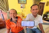 Mohd Affandi (kanan) menunjukkan kad pengenalan arwah bapanya sebagai petunjuk menjejaki abang sulungnya yang terpisah sejak 50 tahun lalu. 
