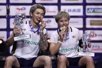 Tang Jie (kiri) dan Ee Wei memegang trofi mereka sambil menggigit pingat emas mereka ketika mereka meraikan di atas podium selepas menewaskan pasangan China, Jiang Zhen Bang-Wei Ya Xin dalam perlawanan akhir beregu campuran di Kejohanan Badminton Dunia di Arena Adidas, Paris tahun lalu. Foto: Agensi