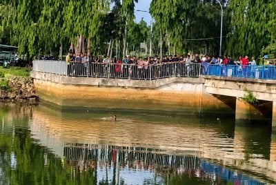 Polis mengambil masa selama 30 minit memujuk seorang lelaki terapung di dalam sungai dalam keadaan berbogel di Gate Air Pengkalan Petah, Tawang, Bachok pada Selasa. Foto tular. 