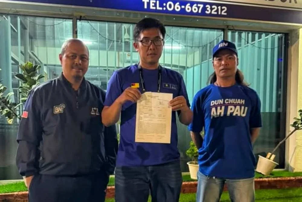 Jeou Ching (tengah) membuat laporan polis berkenaan video tular memaparkan aktiviti mengagih wang yang dikaitkan dengannya