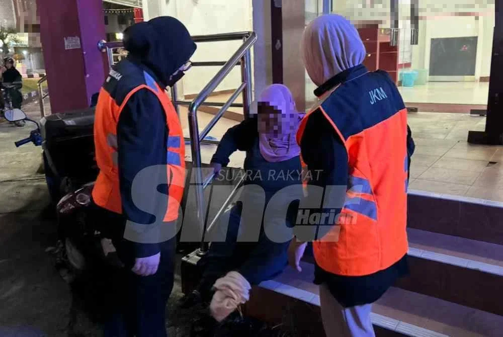 Wanita warga Thailand (tengah) yang dipercayai duduk di kaki lima bank untuk mengemis.
