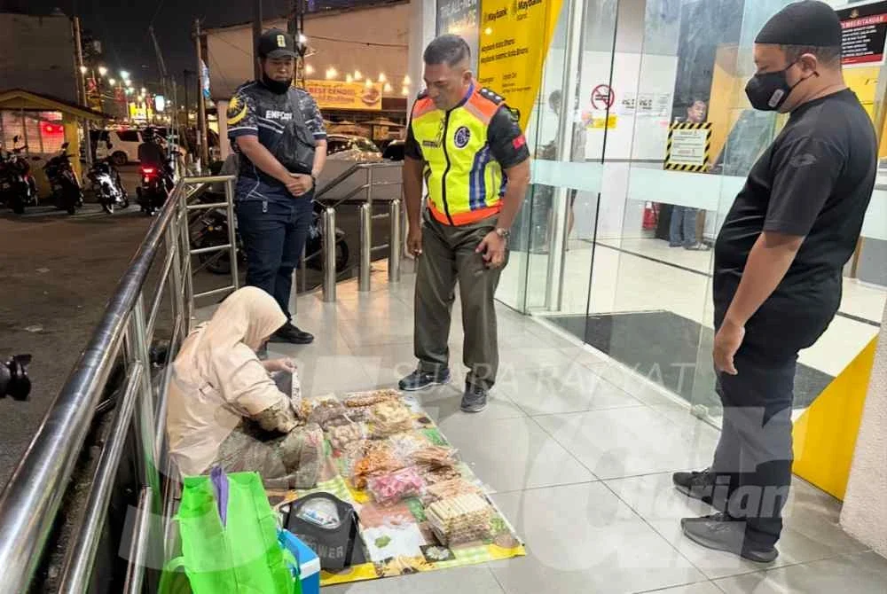 Wanita warga Thailand menjual makanan ringan sebagai helah untuk meraih simpati orang ramai di kaki lima bank. - Foto: SINAR HARIAN/ADILA SHARINNI WAHID