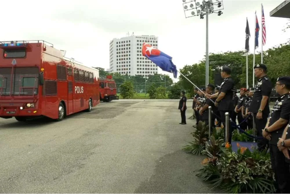 Ab Rahaman mengibarkan bendera sebagai simbolik majlis pelepasan petugas di Ibu Pejabat Polis Kontinjen (IPK) Johor pada Khamis.