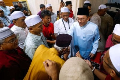 Anwar (tengah) beramah mesra selepas menghadiri Majlis Munajat Perdana Bersama Ustaz Dr Badrulamin di Dewan Orang Ramai Linggi pada Khamis. Foto: Bernama