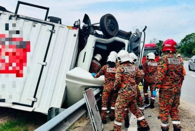 Anggota bomba mengeluarkan mangsa tersepit dalam kenderaan dipandunya. Foto: JBPM Melaka