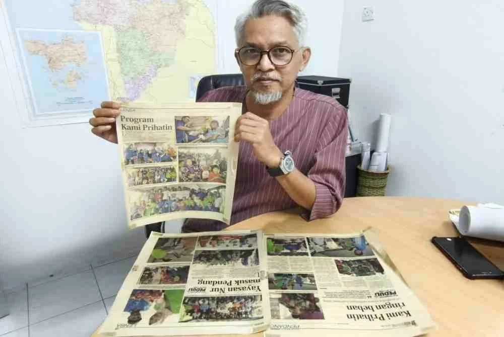 Shaharol Niza menunjukkan keratan akhbar Sinar Harian berhubung penganjuran aktiviti bersama NGO pada tahun 2012.
