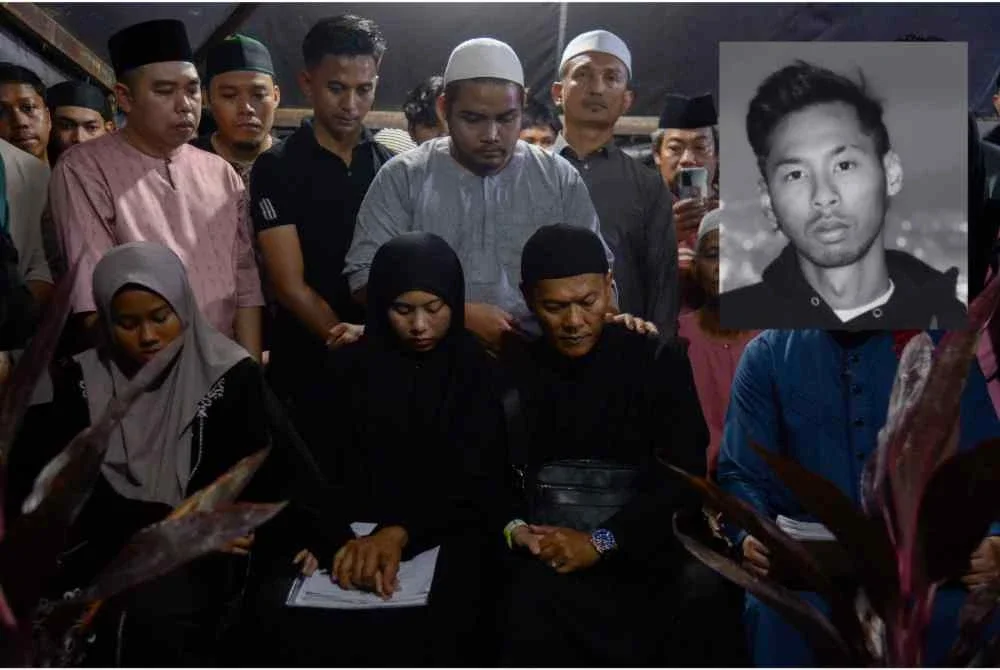 Bapa Ahmad Ros Abidin (dua, kanan) tidak dapat menahan sebak selepas jenazah anaknya disemadikan di Masjid Bandar Tasik Puteri, Rawang hari ini. Foto Bernama.