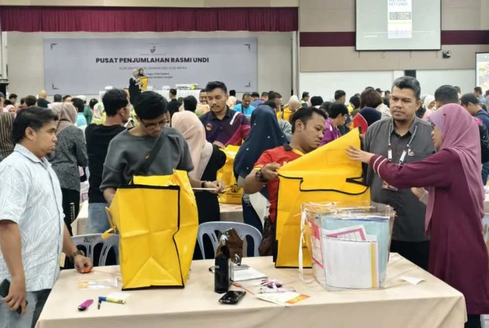 Petugas pilihan raya sedang melaksanakan persediaan di Dewan Perdana Tampin, Jumaat.