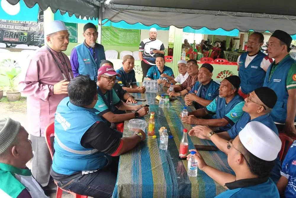 Mohd Fairuz (berdiri dari kiri) ketika beramah mesra dengan jentera pilihanraya Pas.