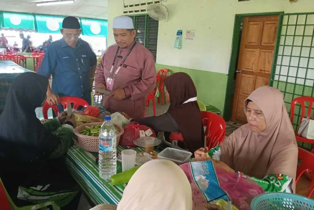 Ahli Parlimen Jerlun, Datuk Abd Ghani Ahmad (kiri) dan Mohd Fairuz ketika meninjau sekitar bilik operasi DUN Serting pada Jumaat.