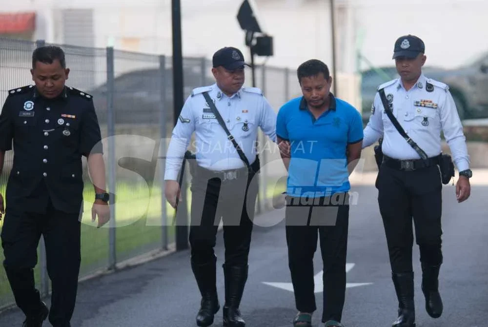 Mohd Norazlan (tengah) yang memakai baju-T berwarna biru, dibawa ke Mahkamah Majistret Kajang pada Jumaat, bagi menghadapi tiga pertuduhan memandu di bawah pengaruh dadah hingga menyebabkan kematian tiga beranak. Foto Sinar Harian