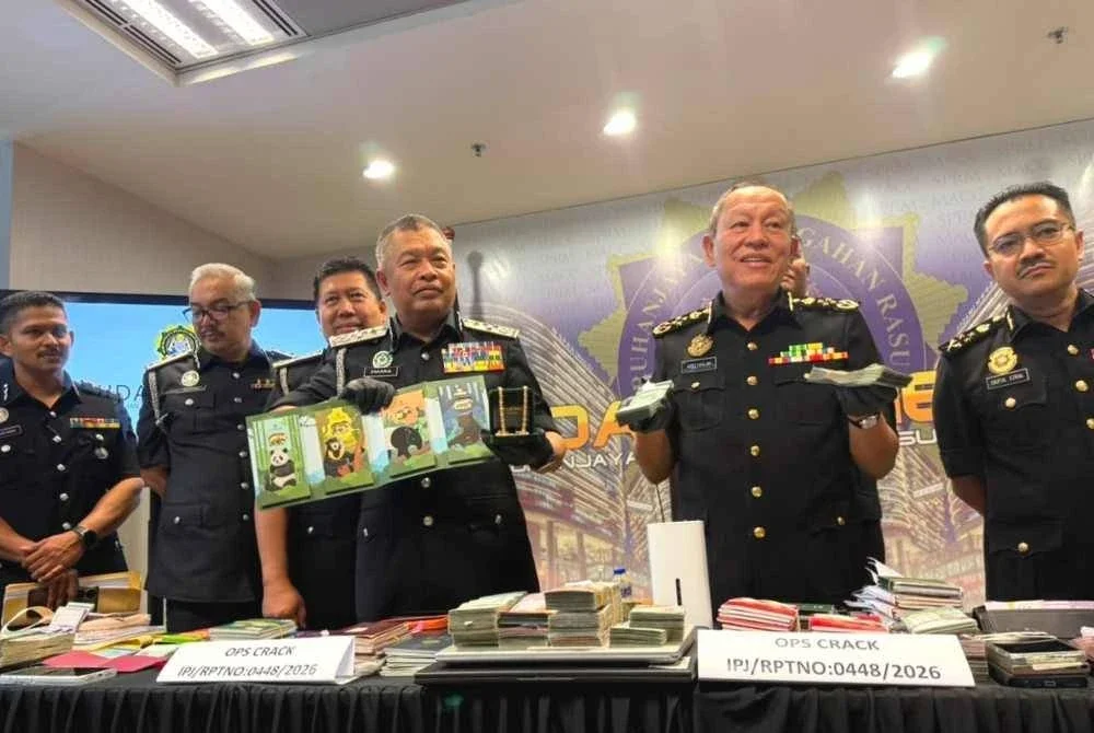 Abd Halim (dua dari kanan) menunjukkan wang tunai yang dirampas menerusi Op Crack membabitkan sindiket godam MyIMMs.