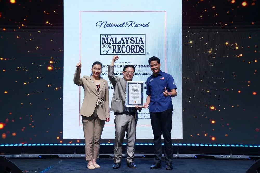 Paul Ang (tengah) dan Pengarah Eksekutif LaundryBar, Sandra Chua Wuan Yeen (kiri) menerima pengiktirafan daripada The Malaysia Book of Records bagi Anugerah Fastest Complete Wash-Dry Cycle Laundry Machine disampaikan sempena Franchise Expo Malaysia 2026, di Pusat Konvensyen Kuala Lumpur (KLCC).