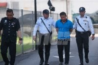 Mohd Norazlan (tengah) yang memakai baju-T berwarna biru, dibawa ke Mahkamah Majistret Kajang pada Jumaat, bagi menghadapi tiga pertuduhan memandu di bawah pengaruh dadah hingga menyebabkan kematian tiga beranak. Foto Sinar Harian