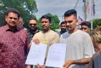 Thayaalaraj (dua dari kiri) dan Sasindran menunjukkan salinan laporan polis yang dibuat di Balai Polis Kampung Bharu Buntong di sini pada Jumaat.