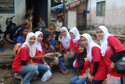 Noor Hayati (lima dari kanan) bersama wartawan Sinar Harian Terengganu merakam gambar kenangan bersama penduduk Orang Asli di Kampung Sungai Berua ketika menjalankan aktiviti komuniti di perkampungan berkenaan pada 2011.