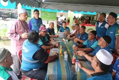 Mohd Fairuz (berdiri dari kiri) ketika beramah mesra dengan jentera pilihanraya Pas.