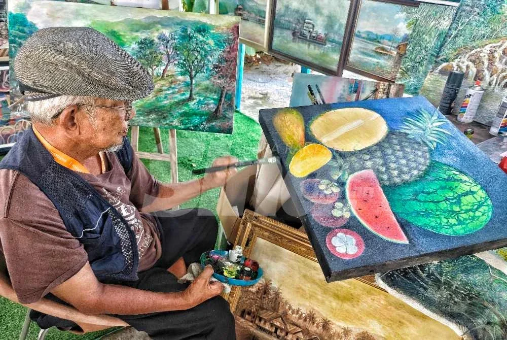 Osman Libat sedang menyiapkan koleksi karya seni visual yang dihasilkan. Foto Sinar Harian