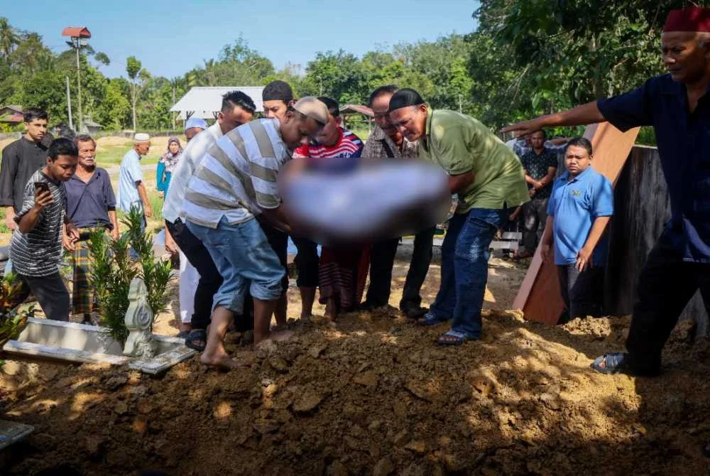 Ahli keluarga dan penduduk kampung bersama-sama mengangkat jenazah Allahyarham Maria dan anak bongsunya, Muhammad Ziekyr Iman untuk dikebumikan dalam satu liang lahad di Tanah Perkuburan Islam Kampung Melor Lama. Foto Bernama