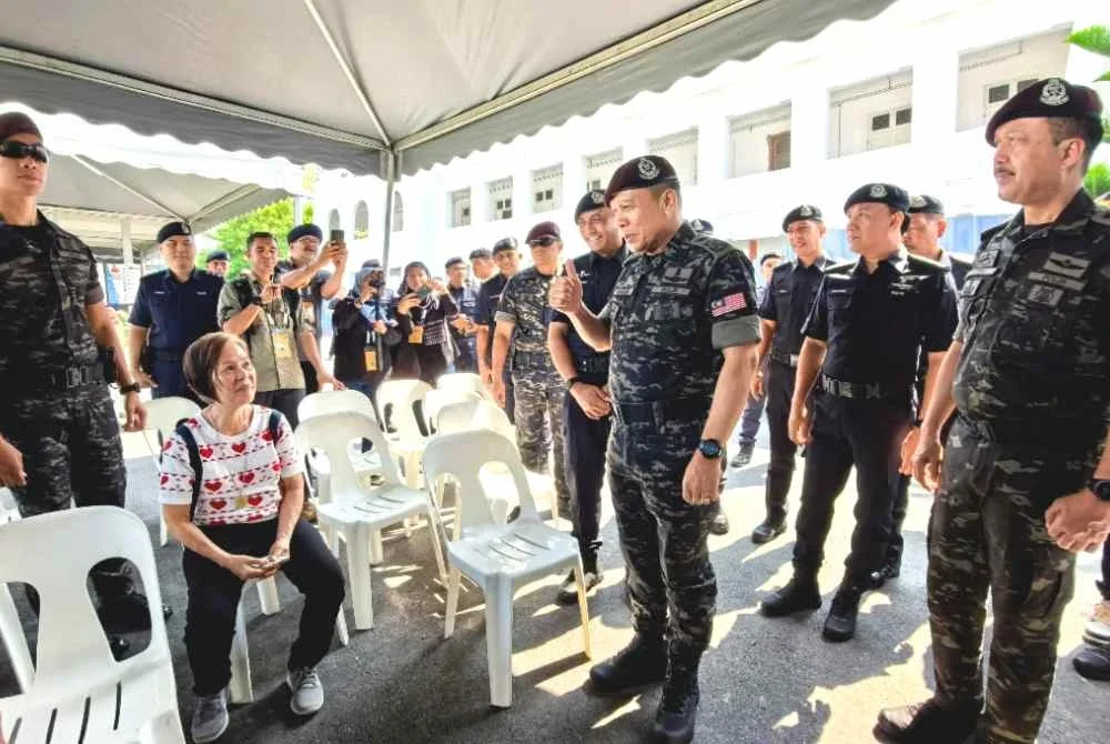 Mohd Khalid beramah mesra bersama pengundi semasa meninjau lokasi proses pengundian PRN Negeri Sembilan di Sekolah Menengah Kebangsaan King George V pada Sabtu. Foto Bernama