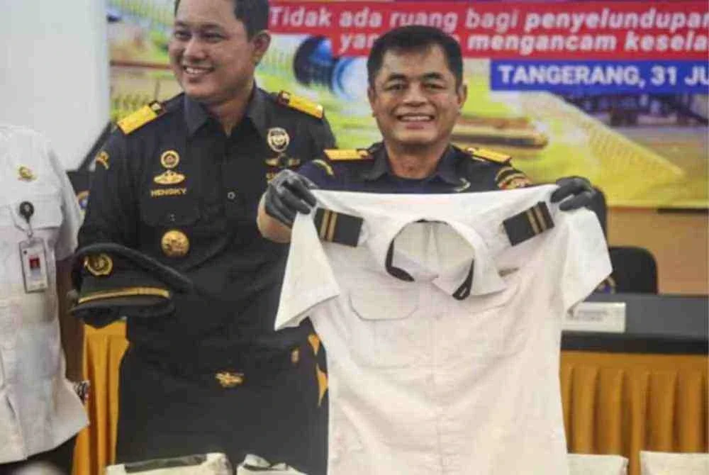 Pegawai kastam Indonesia menunjukkan pakaian seragam seorang juruterbang warga Malaysia bersama dadah yang didakwa cuba diseludup pada sidang akhbar di Lapangan Terbang Antarabangsa Soekarno-Hatta, Tangerang, berhampiran Jakarta. - Foto: AFP