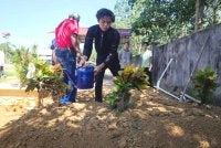 Muhamad Aiman Ashraf, 17, menyiram air di atas pusara ibu dan adiknya di Tanah Perkuburan Islam Kampung Melor Lama. Foto Bernama