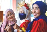 (Dari kiri) Nadzifah, Bahirah dan Zamzarina tampil mengenakan busana bertemakan Jalur Gemilang sebagai tanda semangat patriotik sempena sambutan Bulan Kebangsaan ketika menjalankan tanggungjawab mengundi di SJKC Chung Hua, Rantau. Foto Bernama