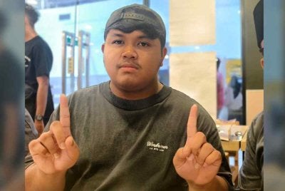 Afif Hakimi menunjukkan jarinya yang masih belum dicelup dengan dakwat.