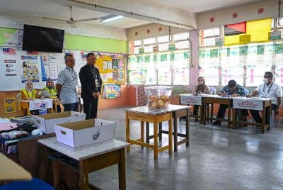 Pengerusi SPR, Datuk Seri Ramlan Harun (berdiri, kanan) meninjau proses pengundian di Pusat Mengundi Sekolah Kebangsaan Taman Paroi Jaya, Seremban sempena PRN Negeri Sembilan Ke-16, hari ini. Foto: Bernama 