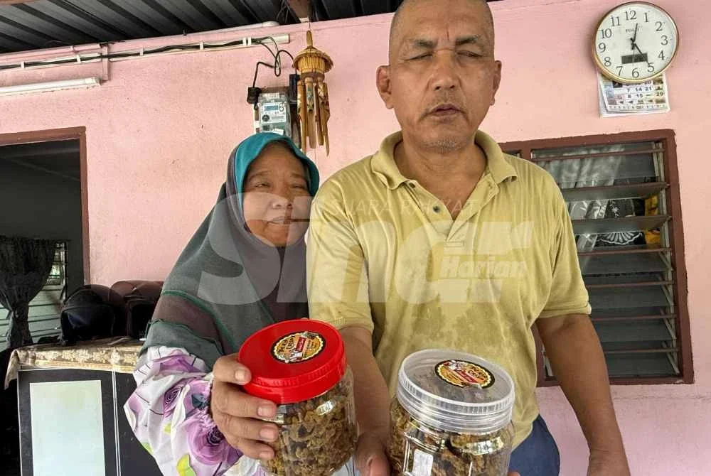 Kamarul Zaman dan isteri menunjukkan peria crispy diusahakan isterinya.