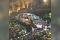 Keadaan kereta selepas terjunam ke Sungai Padas, di belakang sebuah premis di Pekan Beaufort.