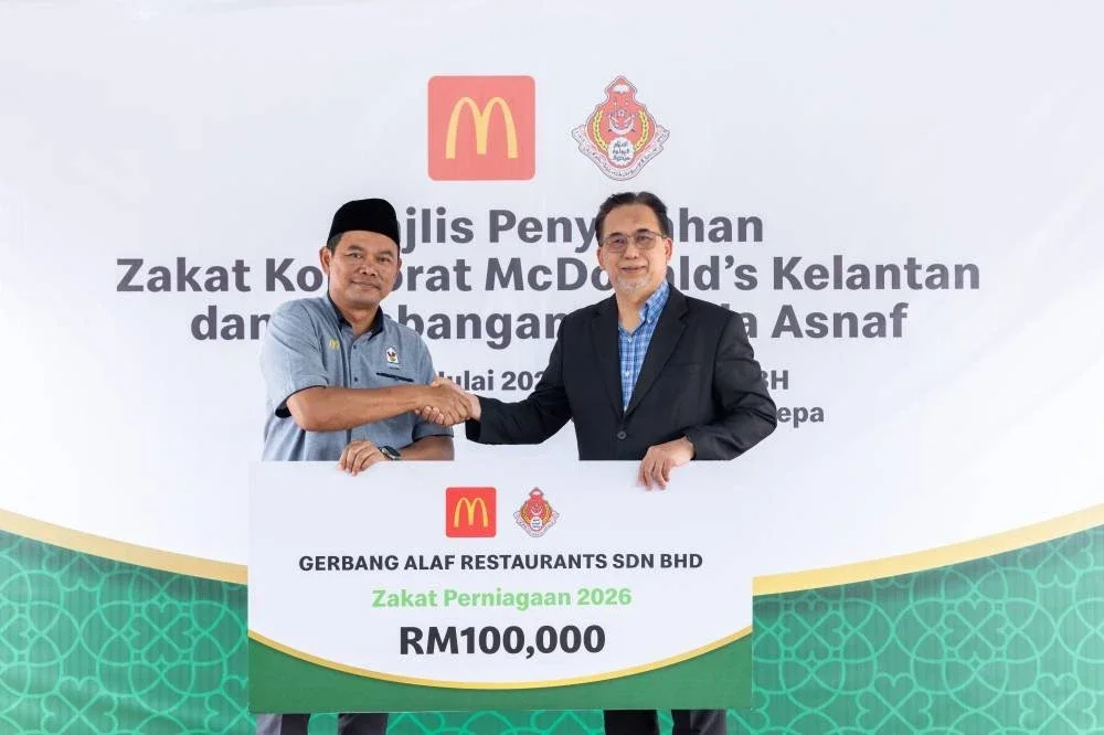 Ahmad Shihafuddin (kiri), menyerahkan cek cura zakat bernilai RM100,000 kepada Mohd Anis (kanan), sempena Majlis Penyerahan Zakat McDonald’s Kelantan di McDonald’s Pandu Lalu Pengkalan Chepa.