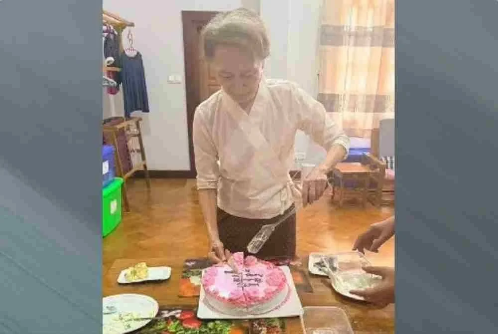 Suu Kyi memotong kek hari jadi.