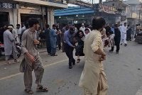 Orang ramai memindahkan mangsa yang cedera selepas serangan pengebom bunuh diri ketika protes di daerah Swat, Pakistan. Foto: AFP