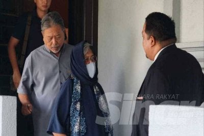 Asnida (kiri) berbincang bersama peguamnya di luar Mahkamah Sesyen Kuala Lumpur pada Isnin.