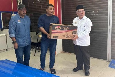 Hassan menyerahkan bantuan kepada sukarelawan skuad bencana di Johor Bahru pada Isnin. 