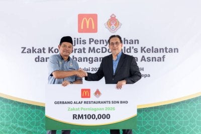 Ahmad Shihafuddin (kiri), menyerahkan cek cura zakat bernilai RM100,000 kepada Mohd Anis (kanan), sempena Majlis Penyerahan Zakat McDonald’s Kelantan di McDonald’s Pandu Lalu Pengkalan Chepa.