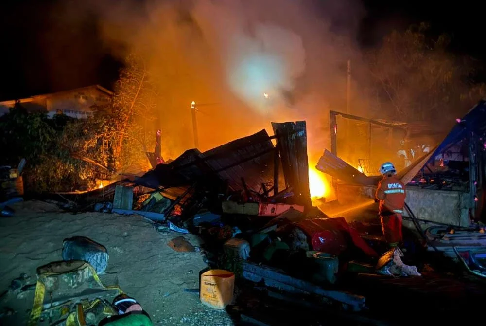 Anggota bomba berusaha memadamkan api yang marak. Foto: JBPM 