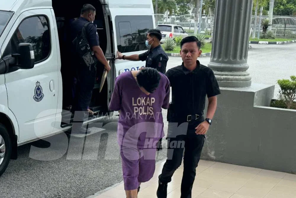 Tertuduh (kiri) yang tiba di mahkamah dengan menggunakan kenderaan polis. Foto SINAR HARIAN/ADILA SHARINNI WAHID