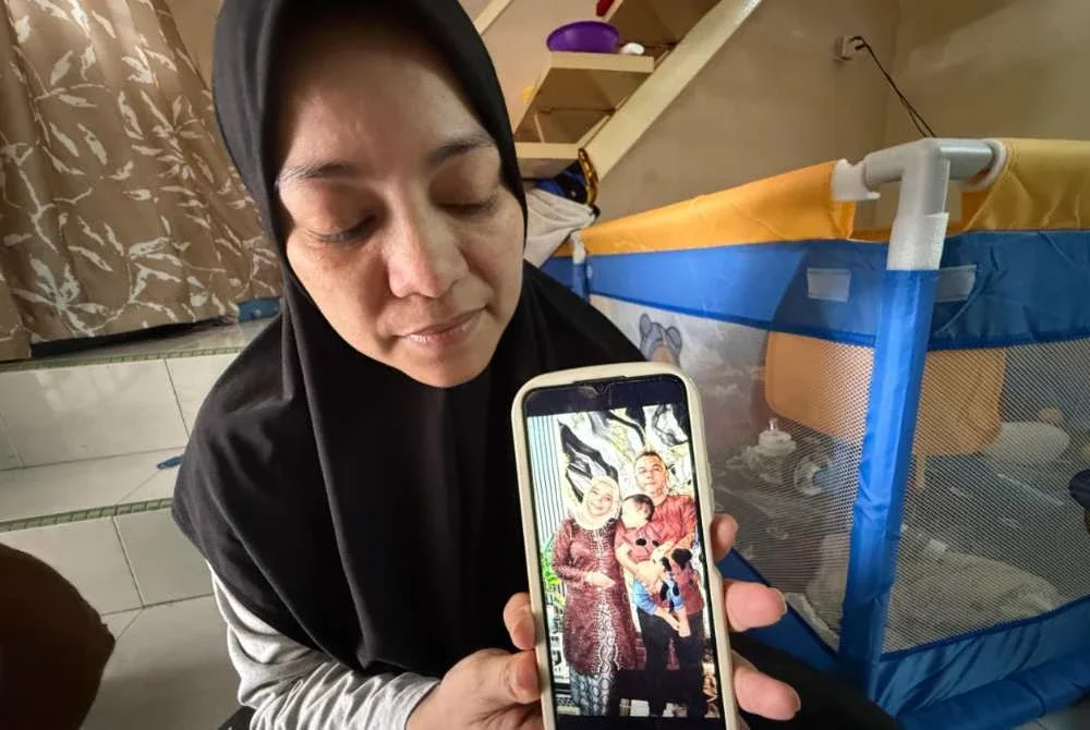 Nor Azliawani menunjukkan gambar kenangan arwah suaminya. Foto SINAR HARIAN/NORAFIZA JAAFAR