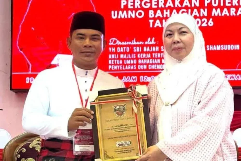 Foto kenangan Allahyarham Mohd Radzi (kiri) menyampaikan cenderamata penghargaan kepada Shahaniza. Foto ihsan Shahaniza
