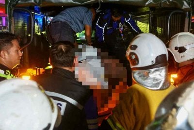 Pasukan penyelamat mengusung mayat lelaki OKU yang maut dalam kebakaran yang memusnahkan rumah keluarganya di Kampung Gong Tok Nasek malam Isnin. Foto Bernama