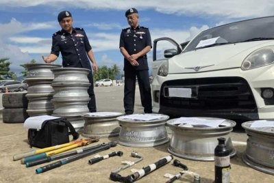 Syed Lot (kanan) menunjukkan rim kereta yang berjaya dirampas dalam beberapa siri serbuan di Putatan dan Penampang.