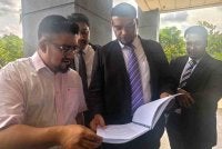 Muhammad Rafique menunjukkan dokumen kepada Chegubard (kiri) ketika di Kompleks Mahkamah Seremban.