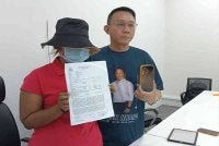 Mangsa yang dikenali sebagai Nini dan Thow Siang menunjukkan salinan laporan polis serta foto didera selepas akhbar di Pusat Aduan Team TLK, Kota Puteri.