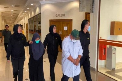 Kedua-dua tertuduh diiringi pegawai SPRM ketika dibawa ke Mahkamah Sesyen di sini untuk pertuduhan pada Rabu.FOTO SPRM PAHANG