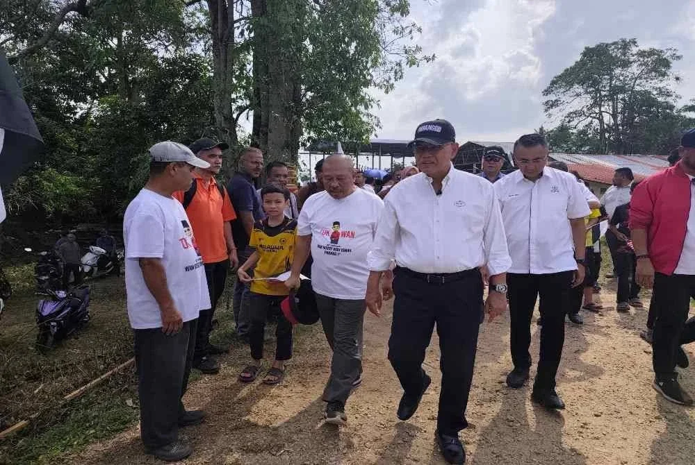 Wan Rosdy diiringi Shafik Fauzan pada program Jelajah Aspirasi Pahang 1st Dewan Undangan Negeri (DUN) Inderapura di Jeti Nelayan Sungai Belat, Kampung Belukar pada petang Rabu. Foto Sinar Harian